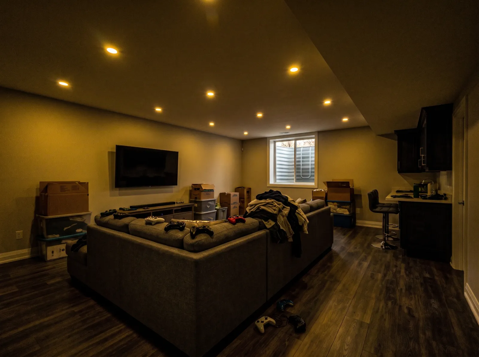 Basement rec room straight off the phone: very dark, noisy, yellow pot-light cast